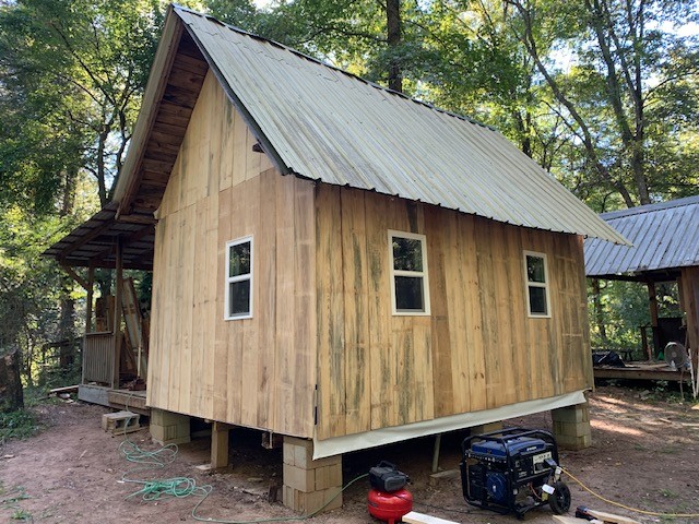 A rustic wooden cabin beside Rum Creek